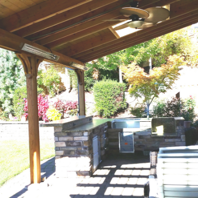 Outdoor kitchen with heaters and ceiling fan in Tigard by Classic Electric