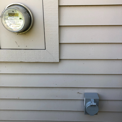 Power inlet box installed outside near electrical meter for use with portable generator